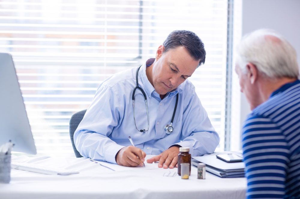 Doctor prescribing medicine to senior patient in clinic